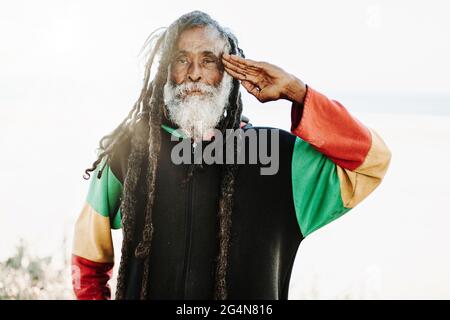 Portrait de l'ancien rastafari avec des dreadlocks regardant l'appareil photo dans la nature avec fond blanc Banque D'Images