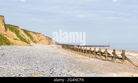 Panorama des galets et des défenses marines qui occupent la plage de West Runton sur la côte nord de Norfolk. Banque D'Images