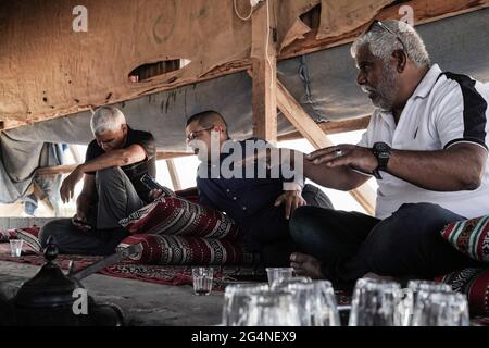 BIR Hadaj, Israël. 22 juin 2021. SALEEM AL DANFEIRI (R), chef du comité local de Bir Hadaj, explique l'avenir incertain et la menace d'expulsion sous laquelle les Bédouins vivent dans les villages non reconnus et les démolitions de maisons dans les cantons légaux de construction illégale dans la tente des visiteurs de la ville bédouine de Bir Hadaj. La bataille politique de plusieurs décennies pour les villages bédouins non reconnus et le développement de ceux qui sont déjà légalisés dans le Negev israélien a pris le pas comme le nouveau gouvernement d'unité Bennett - Lapid dépend du soutien des votes des quatre sièges de la Knesset appartenant à Raam, ONU Banque D'Images