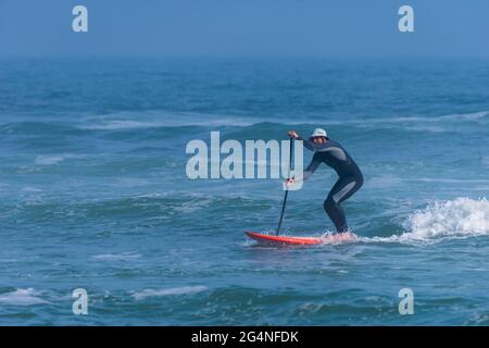 Un homme surfe près de la plage au Johnson Beach National Seashore en Floride le 26 mars 2021. Banque D'Images