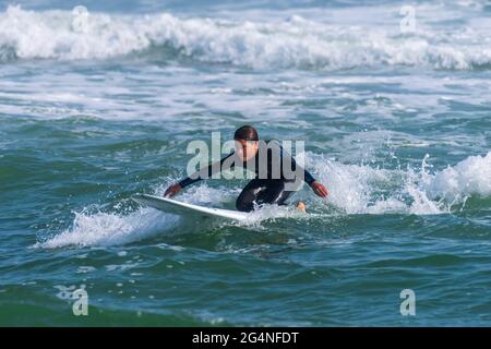 Un homme surfe près de la plage au Johnson Beach National Seashore en Floride le 26 mars 2021. Banque D'Images