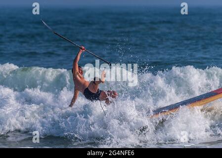 Un homme surfe près de la plage au Johnson Beach National Seashore en Floride le 26 mars 2021. Banque D'Images