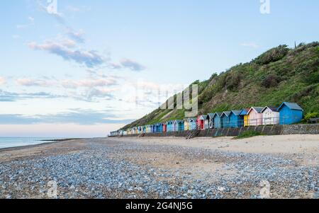 De jolies cabanes de plage bordées sur la plage est de Cromer sur la côte nord de Norfolk, photographiées en juin 2021. Banque D'Images