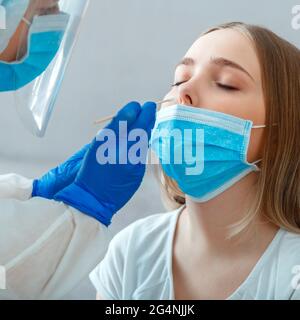 Médecin prenant la culture nasopharyngée à la patiente. L'infirmière prélève l'échantillon de salive dans le nez avec un coton-tige pour vérifier le coronavirus covid 19. Médical Banque D'Images