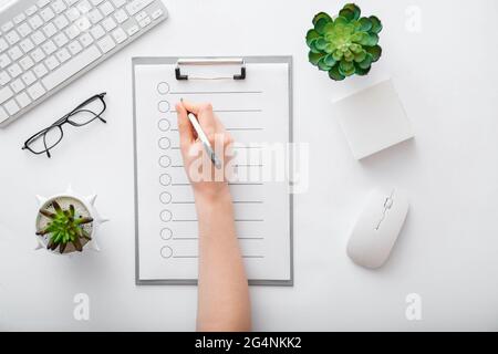 Écriture manuscrite sur une liste vide dans la liste des tâches du bloc-notes. Les mains des femmes prennent des notes sur une tablette papier dans un bureau. Une femme écrit à la main dans un carnet au bureau Banque D'Images