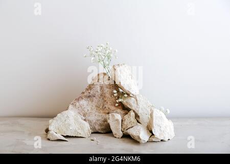 Vide gris pierres tour Podium. Socle en pierre sur fond de béton beige en pierres, maquette de fleurs pour la présentation du produit. Banque D'Images