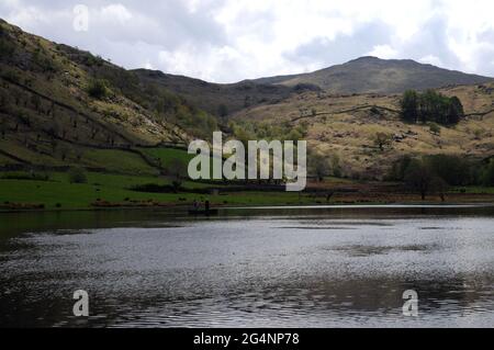 Watendlath Tarn, près du hameau de Watendlath dans le district des lacs anglais. Les pêcheurs à la ligne peuvent souvent être vus pêche à la mouche pour la truite à partir des bateaux sur le tarn. Banque D'Images