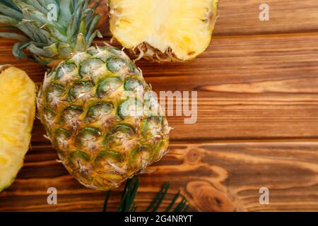 Ananas mûr. Ananas tropical de fruits d'été tranché et ananas entier sur une table en bois brun foncé. Plan de travail avec espace de copie Banque D'Images