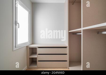 Nouveau mobilier intégré dans un petit dressing. Espace de rangement moderne et vide avec armoire, tiroirs et beaucoup d'espace pour les cintres. Banque D'Images