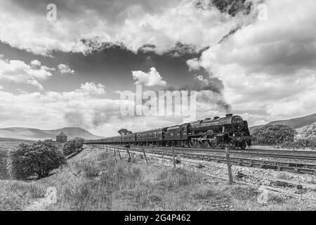 Le Dalesman, dirigé par 46115 Scots Guardsman, passe juste en passant la boîte de signalisation Blea Moor avec la montagne Ingleborough en arrière-plan Banque D'Images