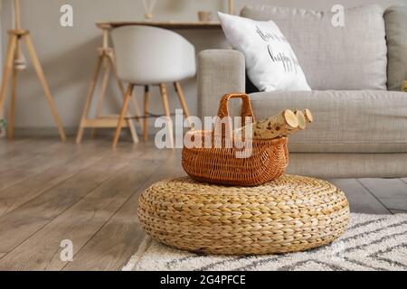 Panier avec bois de chauffage sur le sol dans la salle de séjour Banque D'Images