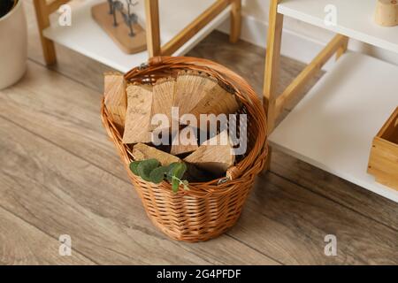 Panier avec bois de chauffage au sol dans la chambre Banque D'Images