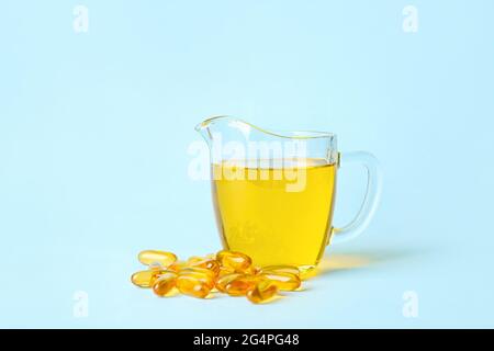 Carafe d'huile de poisson et capsules sur fond de couleur Banque D'Images