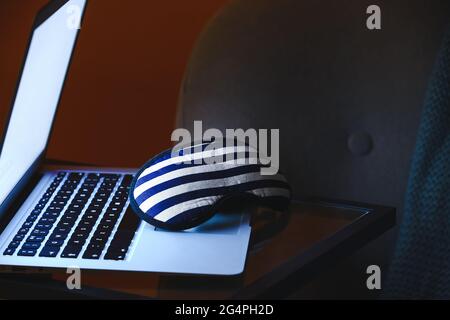 Élégant masque de couchage et ordinateur portable sur la table dans la chambre Banque D'Images