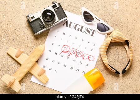 Calendrier avec dates marquées et accessoires de plage sur le sable Banque D'Images