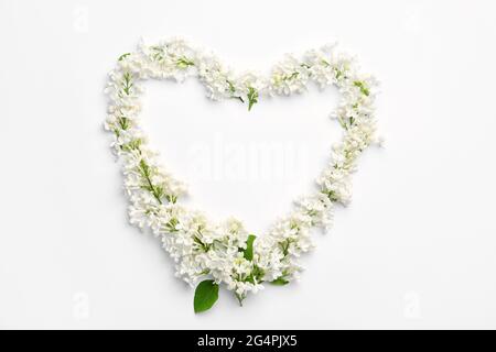 Coeur fait de belles fleurs lilas sur fond blanc Banque D'Images