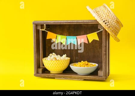 Boîte de maïs savoureux, pop-corn et chapeau de fermier sur fond de couleur. Fête de Festa Junina (Festival de juin) Banque D'Images