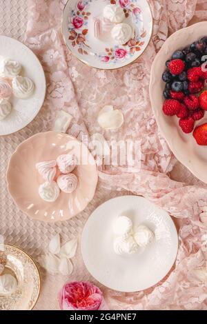Assiettes claires et brillantes de meringue aux baies, fraises, framboises et bleuets de saison Banque D'Images