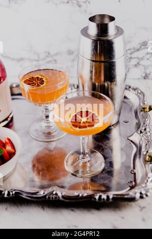 Cocktails d'été à l'orange et aux fraises servis sur une assiette de service en métal vintage. Banque D'Images