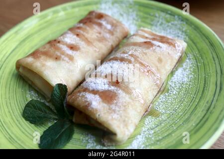 Assiette verte avec crêpes farcies au restaurant Banque D'Images