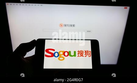 Personne tenant un smartphone avec le logo de la société chinoise de technologie Sogou Inc. Sur l'écran devant le site Web. Mise au point sur l'affichage du téléphone. Banque D'Images