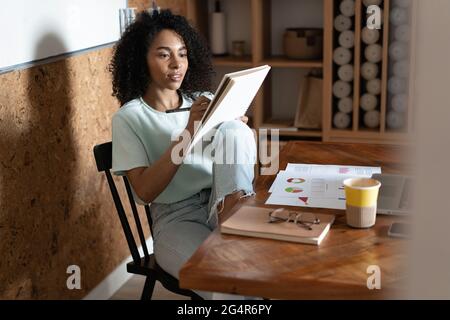 Jeune femme afro-américaine créative du millénaire travaillant au bureau. Banque D'Images