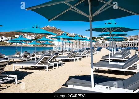 Parasols de plage et chaises longues à Ornos. Mykonos, Grèce. Banque D'Images