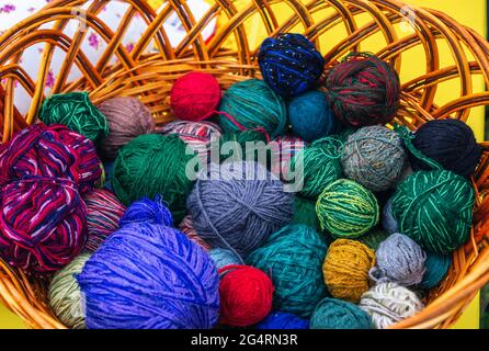 Balles de tricot colorées – laine et fils de coton dans un panier en osier. Banque D'Images