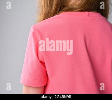 Gros plan du t-shirt rouge-cheveux fille rose épaule, manche et dos. Vue arrière. Vêtements d'été Banque D'Images