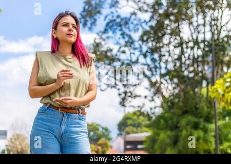 latina femme dans un parc faisant un geste de compassion avec ses mains Banque D'Images