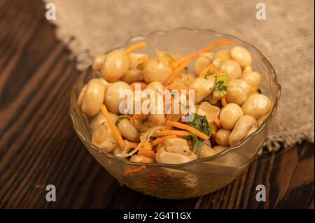 Champignons salés dans un plat en verre sur une table en bois. Gros plan mise au point sélective Banque D'Images