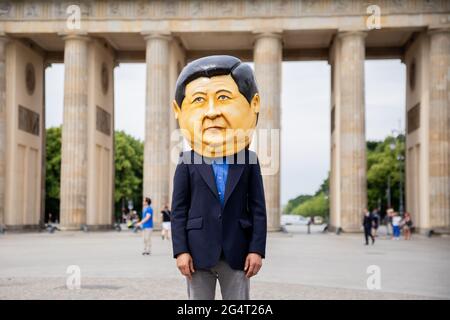 Berlin, Allemagne. 23 juin 2021. Un participant à une manifestation de plusieurs organisations de défense des droits de l'homme contre l'attribution des Jeux olympiques d'hiver de 2022 à Pékin se tient devant la porte de Brandebourg portant un masque destiné à représenter le président chinois Xi Jinping. Credit: Christoph Soeder/dpa/Alay Live News Banque D'Images