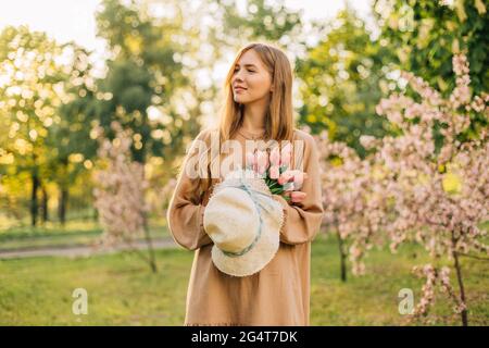 Portrait d'une belle jeune femme dans un jardin de pommiers fleuris au printemps, profitant de la nature, concept de printemps, belle fille dans le jardin Banque D'Images