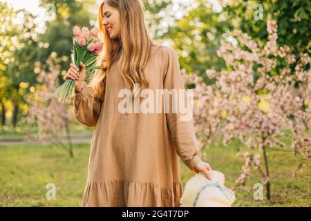 Portrait d'une belle jeune femme dans un jardin de pommiers fleuris au printemps, profitant de la nature, concept de printemps, belle fille dans le jardin Banque D'Images