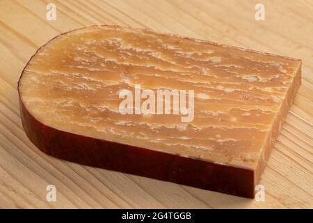 Tranche de vieux fromage de brebis hollandais mûr sur une planche à découper Banque D'Images