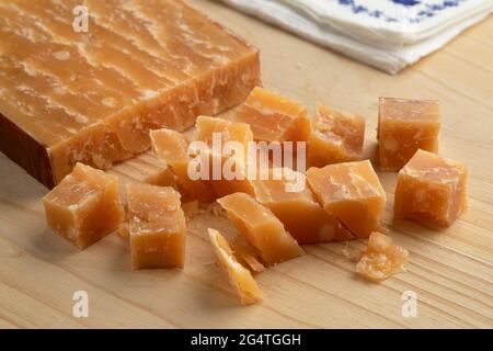 Cubes de vieux fromage de brebis hollandais mûr sur une planche à découper Banque D'Images