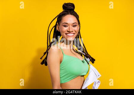 Photo de charmante belle afro américaine jeune femme sourire cheveux de mouche isolés sur fond jaune Banque D'Images