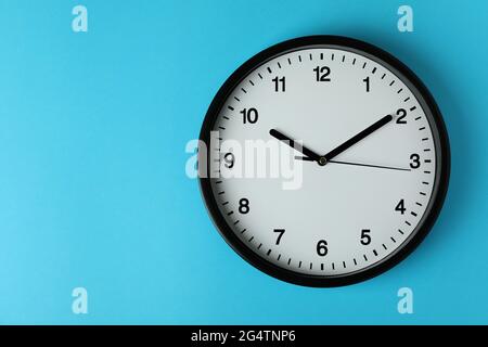 Horloge de bureau noire standard sur fond bleu Banque D'Images