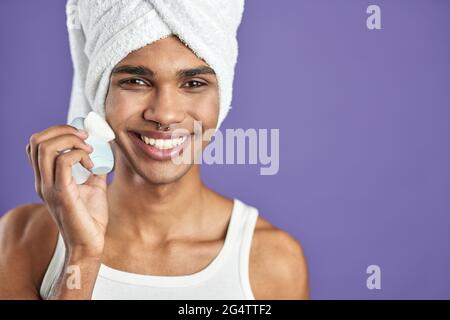 Afroamerican transgenre jeune homme regardant la caméra et sourire dans une serviette. TRANS sexe hommes soins de la peau Banque D'Images