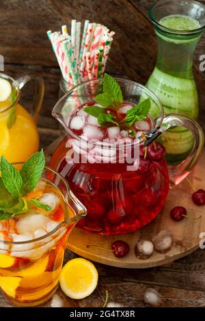 Boissons froides glacées avec fruits frais dans des pichets en verre Banque D'Images