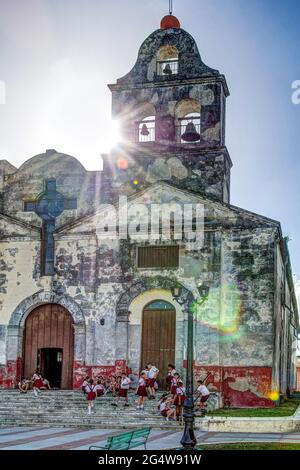 Les pionniers cubains devant une vieille église catholique par une journée ensoleillée avec trois cloches et croix sur le toit, les écoliers traînaient sur les escaliers devant la TH Banque D'Images