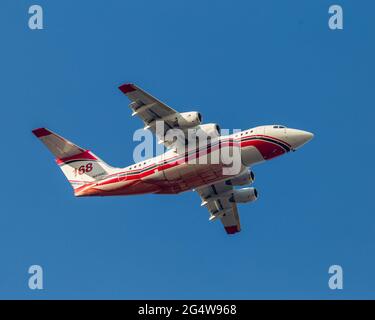 Avro RJ-85 repassant à la base après avoir laissé tomber le produit ignifuge sur le feu de forêt du Canyon, à gauche. Le produit ignifuge est visible le long du ventre de l'avion et de la fusela Banque D'Images