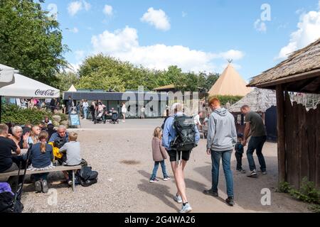 Ebeltoft, Danemark - 21 juillet 2020 : les gens sont assis et mangent à l'extérieur sur un banc, derrière une grande tente amérindienne Banque D'Images