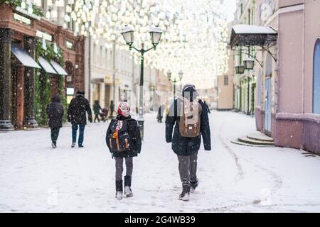 deux enfants se promo dans les rues de la ville en hiver sous la neige Banque D'Images