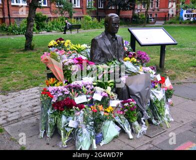 Des fleurs entourent la statue et le mémorial Alan Turing, Sackville Gardens, Manchester, Angleterre, Grande-Bretagne, Royaume-Uni, le 23 juin 2021, date anniversaire de l'anniversaire de Turing. Alan Mathison Turing OBE était un mathématicien anglais, un informaticien, un logicien et un cryptanalyste. Au cours de la Seconde Guerre mondiale, il a dirigé une équipe chargée de briser les chiffriers allemands de la machine Enigma. Turing a alors eu une influence dans le développement de l'informatique à l'Université de Manchester. Banque D'Images