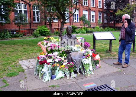 Des fleurs entourent la statue et le mémorial Alan Turing, Sackville Gardens, Manchester, Angleterre, Grande-Bretagne, Royaume-Uni, le 23 juin 2021, date anniversaire de l'anniversaire de Turing. Alan Mathison Turing OBE était un mathématicien anglais, un informaticien, un logicien et un cryptanalyste. Au cours de la Seconde Guerre mondiale, il a dirigé une équipe chargée de briser les chiffriers allemands de la machine Enigma. Turing a alors eu une influence dans le développement de l'informatique à l'Université de Manchester. Banque D'Images