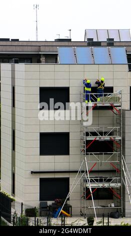 Deux ouvriers réparant l'ingression de l'eau derrière le revêtement sur un bloc vieux de 1 ans d'appartements Santander Cantabria Espagne Banque D'Images