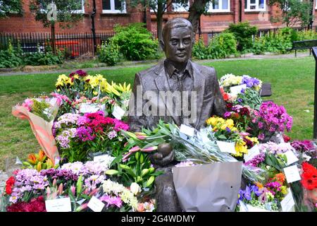 Des fleurs entourent la statue et le mémorial Alan Turing, Sackville Gardens, Manchester, Angleterre, Grande-Bretagne, Royaume-Uni, le 23 juin 2021, date anniversaire de l'anniversaire de Turing. Alan Mathison Turing OBE était un mathématicien anglais, un informaticien, un logicien et un cryptanalyste. Au cours de la Seconde Guerre mondiale, il a dirigé une équipe chargée de briser les chiffriers allemands de la machine Enigma. Turing a alors eu une influence dans le développement de l'informatique à l'Université de Manchester. Banque D'Images