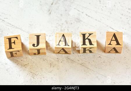 Cinq cubes en bois avec le mot FJAKA (terme dalmatien pour l'art de ne rien faire) sur la pierre blanche comme le tableau, vue d'en haut Banque D'Images
