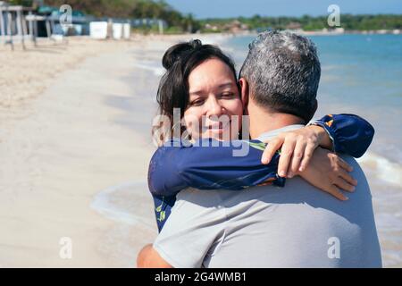 Couple hispanique d'âge moyen qui s'embrasse sur une plage. Banque D'Images